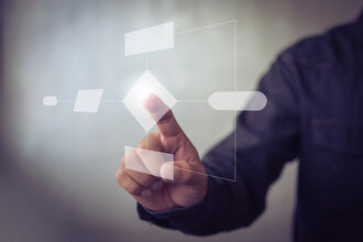 Eine Person in dunkelblauem Hemd tippt auf eine digitale, perspektivisch im Vordergrund stehende Komponente eines virtuellen Systemplans. Dieses Motiv repräsentiert den Bereich SYSTEME & STRUKTUR der offino Bürolösungen GmbH
